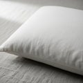 A white pillow with a smooth texture resting on a light gray fabric surface. The pillow Royalty Free Stock Photo