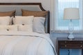 White pillows on white bed with luxury lamp in bedroom at home