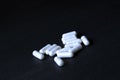 White pills on black background in abstract style on white background.