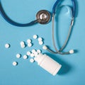 White Pills, Bottle And Stethoscope On Blue Background, Top View. Medicine Healthcare Pharmacy Concept. Coronavirus Royalty Free Stock Photo