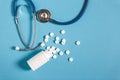 White Pills, Bottle And Stethoscope On Blue Background, Top View. Medicine Healthcare Pharmacy Concept