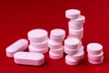 White pills on a bright red background. Close-up. Royalty Free Stock Photo