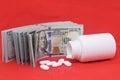 White pills fall out of a white pill bottle on a red background. Macro Focus on the foreground, soft bokeh. pills Royalty Free Stock Photo