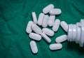 White pills on green background, top view, Closeup. Royalty Free Stock Photo