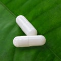White pills on a green leaf Royalty Free Stock Photo