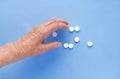 White pills on the hand of an elderly man close-up. Royalty Free Stock Photo