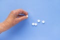 White pills on the hand of an elderly man close-up. Royalty Free Stock Photo