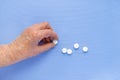 White pills on the hand of an elderly man close-up. Royalty Free Stock Photo