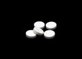 White pills isoltaed on black