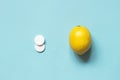 White pills and lemon on a blue background. The choice of treatment with medicines or folk remedies. Flu, colds Royalty Free Stock Photo