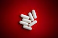 White pills on red background, . Selective focus Royalty Free Stock Photo