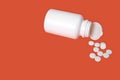 White pills scattered in a white jar on red background. selective focus. concept of health Royalty Free Stock Photo
