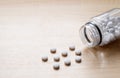 White pills are scattered on a wooden table.  Empty space on the left. Royalty Free Stock Photo