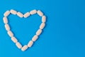 White pills in the shape of a heart. Royalty Free Stock Photo