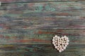 White pills in the shape of a heart on a wooden background Royalty Free Stock Photo