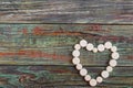 White pills in the shape of a heart on a wooden background Royalty Free Stock Photo