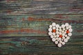 White pills in the shape of a heart on a wooden background Royalty Free Stock Photo