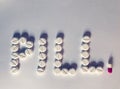 White pills spelling the word Pill. Royalty Free Stock Photo