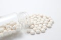 White pills spilling out of a transparent medicine bottle. Royalty Free Stock Photo