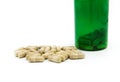 White pills spilling or pour out of green pill bottle isolated on white background with copy space for add text. Royalty Free Stock Photo