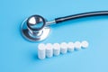White pills or tablets stacked on each other in the form of steps and stethoscope Royalty Free Stock Photo