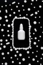 White pills, tablets and white bottle on black background