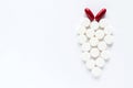 White pills and two red capsules on white background. Pharmaceutical medicament. Antibiotic, painkiller or narcotic, closeup Royalty Free Stock Photo