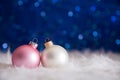 White and pink Christmas balls on fur with garland lights on blu Royalty Free Stock Photo