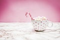 White Pink Christmas mug with marshmallows, sugar cane on a cozy sweaters and pink background