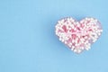 White and pink cotton swabs in a heart container on blue paper background