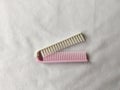 white and pink folding comb with a white background