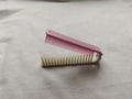 white and pink folding comb with a white background