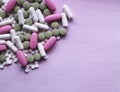 White, pink and green pills on a pink background. multi-colored drugs.