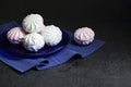 White and pink marshmallow on blue plate on black background Royalty Free Stock Photo