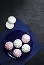 White and pink marshmallow on blue plate on black background Royalty Free Stock Photo