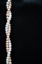 White and pink pearls on the black silk background Royalty Free Stock Photo