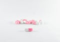 The white-Pink pills spilling from a white plastic bottle on white b Royalty Free Stock Photo