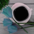 A white-pink square cup of coffee , three blue tulips Royalty Free Stock Photo