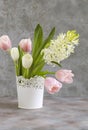 White and pink tulips and hyacinths in a white vase