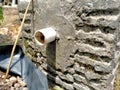 The white pipeline shower is occurring on the wall cement surface of pond