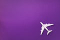 White plane, airplane on violet color background with copy space. Top view, flat lay. Minimal style design. Travel, vacation