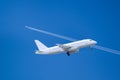 white plane taking off and airplane flying above and behind in clear blue sky with white condensation trails Royalty Free Stock Photo