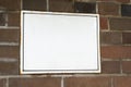 White plaque on a brick wall with space for text. Informant pointer. Signboard copy space