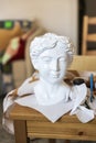 A white plaster female head for coloring on the table, Royalty Free Stock Photo