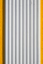 White plastered panel texture with vertical grooves against yellow wall Royalty Free Stock Photo