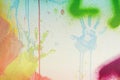 White plastered wall with colorful drips, flows and paint sprays. Handprints on white wall background Royalty Free Stock Photo