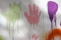 White plastered wall with colorful drips, flows and paint sprays. Handprints on white wall background Royalty Free Stock Photo