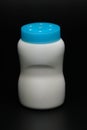 White plastic baby powder bottle isolated on black background. Royalty Free Stock Photo