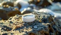 White plastic bottle cap on rocky beach with small pebbles and sand at sunset Royalty Free Stock Photo