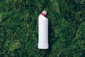 White plastic bottle of cleaning product, household chemicals or liquid laundry detergent on green grass, moss Royalty Free Stock Photo